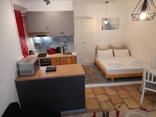 eine Küche und ein Wohnzimmer mit Sofa in der Unterkunft STUDIO PORTO in Korfu-Stadt