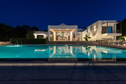 una villa con piscina di notte di Villa Syndriani a Paradeísi