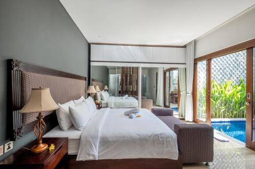 a bedroom with a large bed and a pool at PANDAWA VILLAS SEMINYAK in Seminyak