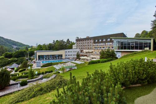 a building on a hill with a garden at Hotel Sitno Forest Resort in Vyhne
