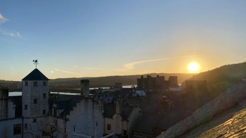 zachód słońca nad miastem z zamkiem w obiekcie Gwynfryn w mieście Conwy