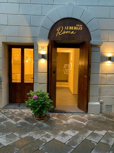 an entrance to a hotel with a potted plant at Albergo Roma in Buonconvento