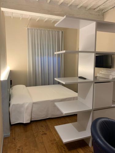 Albergo Roma في بونكونفينتو: غرفة نوم بسرير أبيض ورفوف