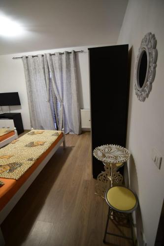 a bedroom with a bed and a table and a window at Agropensiune CASA SONIA in Băcia