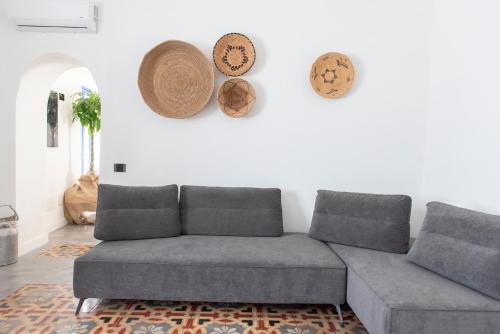 a living room with a couch and plates on the wall at Albergo Rurale Casa Fois in Valledoria