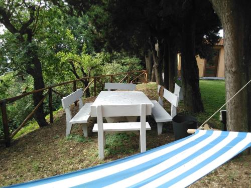 a white table and chairs under a tree at Villa Pilar in Toscana con piscina ultrapanoramica in Montevettolini