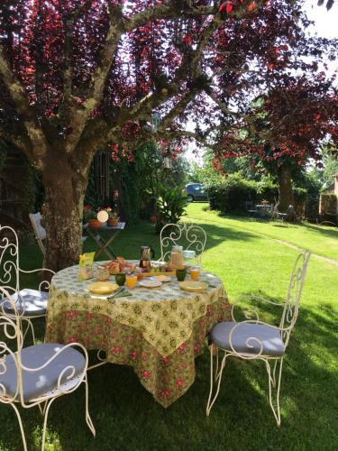 een tafel met borden eten onder een boom bij La Maison Magique in Saint-Chamassy