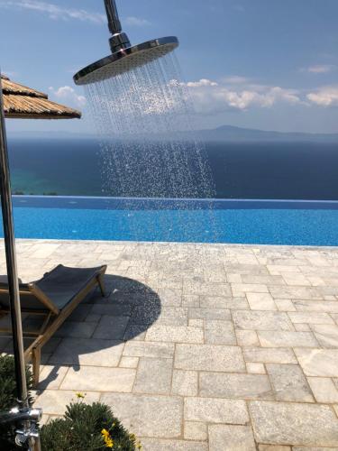 a pool with a water sprinkler next to a pool at Petra Thea in Kalamata