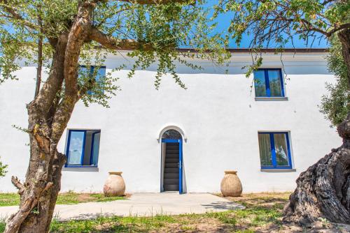 a white house with a blue door at Albergo Rurale Casa Fois in Valledoria