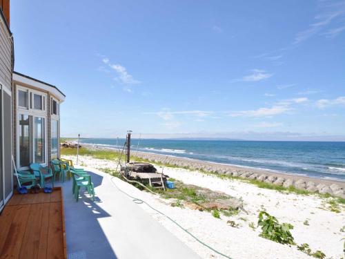 a house with a balcony with a view of the beach at Pension Arumeria in Wakkanai