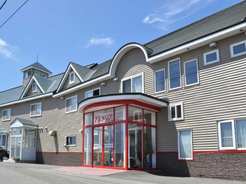 a building with a red phone booth in front of it at Pension Arumeria in Wakkanai