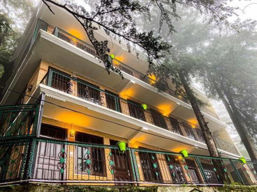 a building with a balcony with lights on it at Jakhu Vibes in Shimla