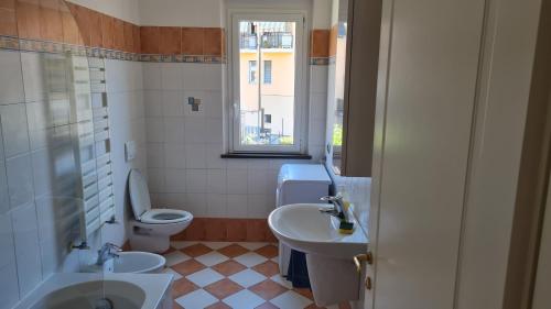 łazienka z umywalką, toaletą i oknem w obiekcie La Contrada w mieście Casarza Ligure