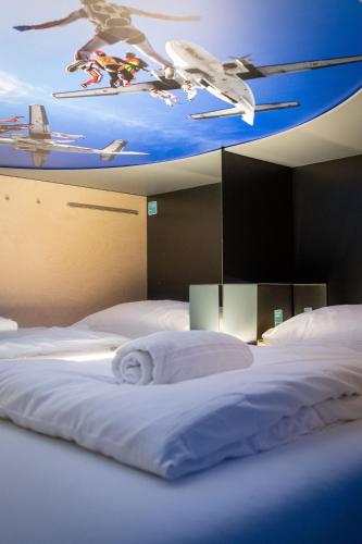 a bedroom with two beds with a painting on the ceiling at Capsule Hotel - Lucerne TheLAB in Luzern
