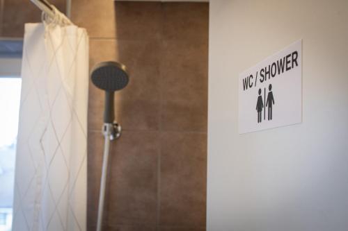 a bathroom with a shower with a sign that says way stronger at Capsule Hotel - Lucerne TheLAB in Luzern