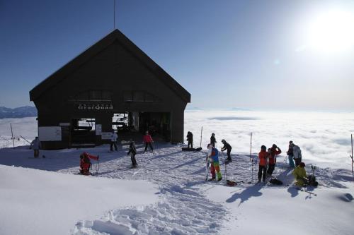 a group of people standing outside of a building in the snow at Hotel Oak Forest in Hakuba