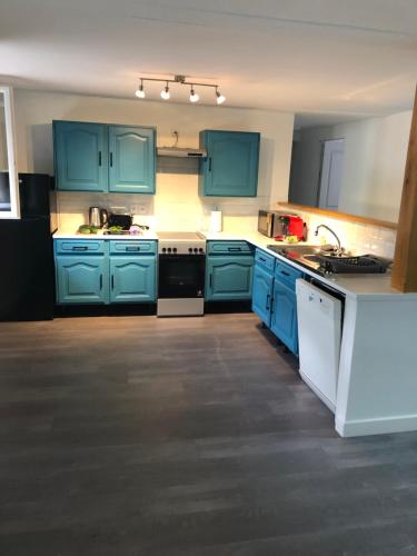 a kitchen with blue cabinets and white appliances at les gîtes d'en Julio in Puylaurens