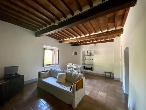 a living room with a white couch and a table at Window to Bagno Vignoni in Bagno Vignoni