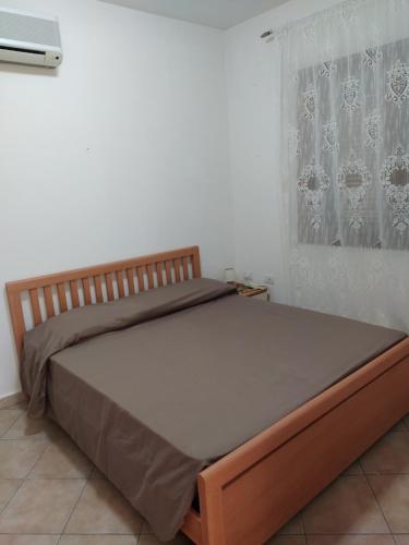 a large bed in a bedroom with a window at LA CALA in Olbia