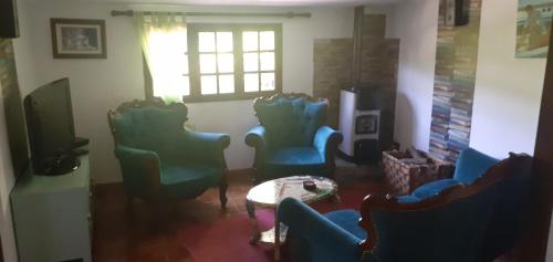 sala de estar con sillas, mesa y ventana en cottage, en Abragão