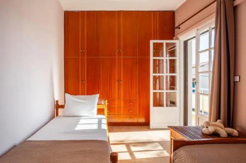 a bedroom with a bed and a table and a window at Rena's Hospitality walk to the beach,10min to Chania! in Kato Daratso