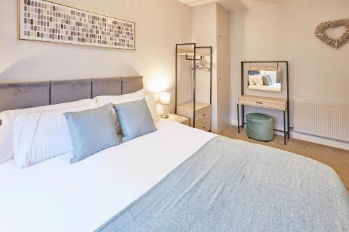een slaapkamer met een groot wit bed met blauwe kussens bij Host & Stay - The Avenue Victoria Apartment in Scarborough