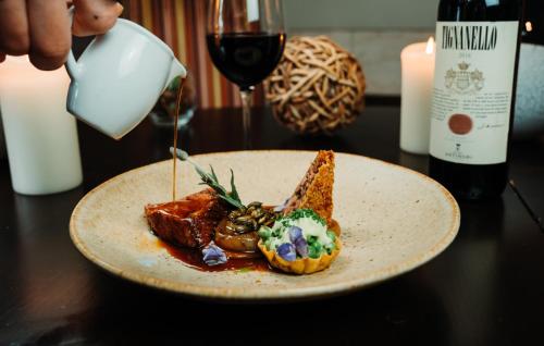 un plato de comida en una mesa con una copa de vino en Feversham Arms Hotel & Verbena Spa, en Helmsley