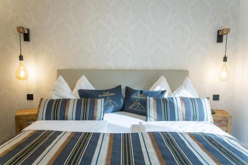 a bedroom with two beds with blue and white pillows at Club Alpenresidenz Gastein in Bad Gastein
