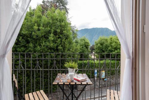a table and chairs on a balcony with a view at Lake Como Studio with Balcony and Private Parking in Ossuccio