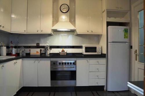 cocina con armarios blancos y nevera blanca en Apartamento Turístico Almagre, en Almagro