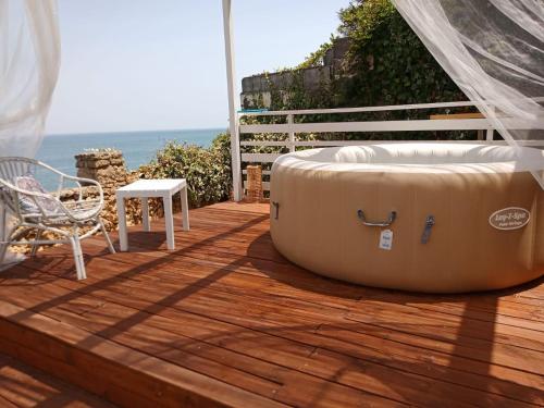 a large tub sitting on a deck with a table and a chair at Villa Sciammaca in Brucoli