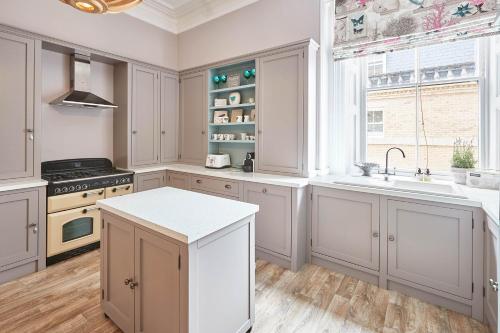 a kitchen with white cabinets and a sink and a window at Host & Stay - The Zetland Apartment in Saltburn-by-the-Sea