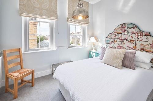 a bedroom with a bed and a chair and windows at Host & Stay - The Zetland Apartment in Saltburn-by-the-Sea
