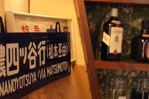 a bottle of wine on a shelf next to a sign at Hakuba Skala Inn in Hakuba