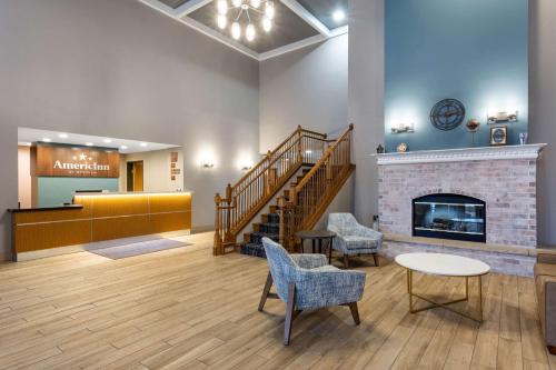 a lobby with a staircase and a fireplace at AmericInn by Wyndham Fulton Clinton in Fulton