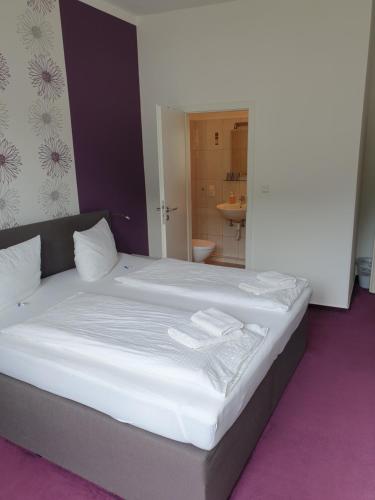 a large bed with white sheets and towels on it at Haus Burgfrieden Cochem in Cochem
