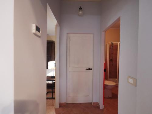 a hallway with a white door and a toilet at Tenuta San Giorgio in Serravalle Scrivia