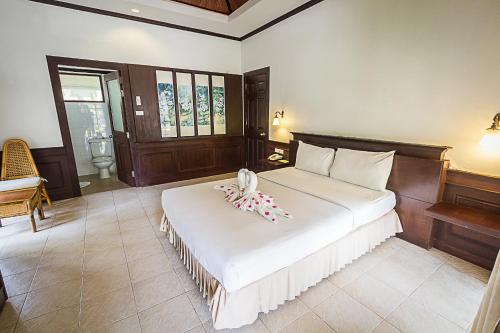 a bedroom with a bed with a pacifier on it at Coco Palm Beach Resort - SHA Extra Plus in Mae Nam