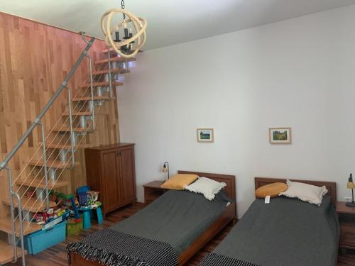 um quarto com 2 camas e uma escada em espiral em Apartament na Wzgórzu em Wisla