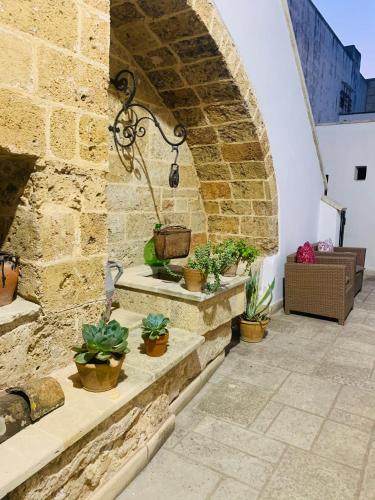 a patio with potted plants on a stone wall at Nonna Veronica in Gemini