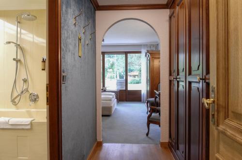 a hallway with a bathroom with a shower and a tub at Adolphine Garden in Rottach-Egern