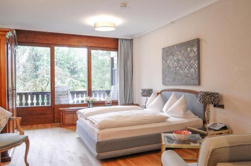 a bedroom with a bed and a balcony at Adolphine Garden in Rottach-Egern