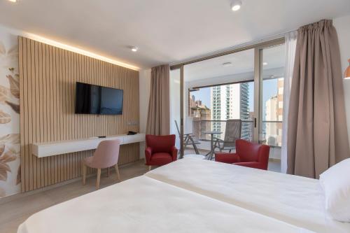a hotel room with a large bed and a balcony at Aparthotel BCL Levante Beach in Benidorm