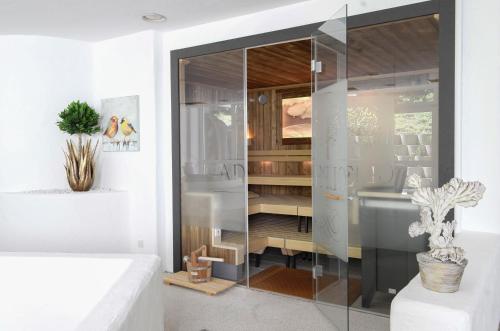 a glass shower in a bathroom with a sink at Adolphine Garden in Rottach-Egern