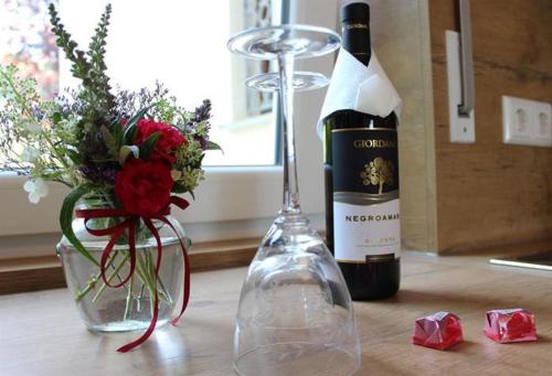 eine Flasche Wein und eine Vase Blumen auf dem Tisch in der Unterkunft Ferienapartments Klatte in Wangen im Allgäu