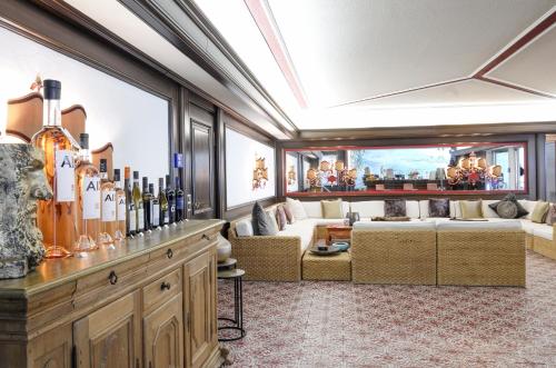 a room with a couch and a table with bottles of wine at Adolphine Garden in Rottach-Egern