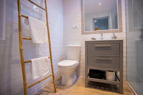 a bathroom with a toilet and a sink and a mirror at Flor de Iris in Sierra Nevada