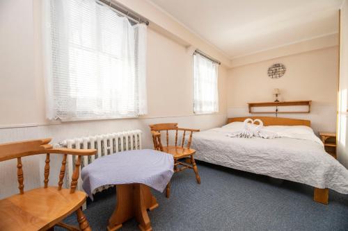 a bedroom with two beds and two chairs at penzion Vysoká Stráž in Pec pod Sněžkou