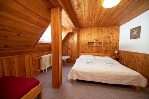 a bedroom with a bed in a wooden room at penzion Vysoká Stráž in Pec pod Sněžkou