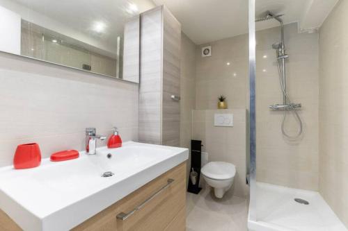 une salle de bain avec un lavabo, des toilettes et une douche dans l'établissement Appartement Grands Boulevards - 21 -, à Paris